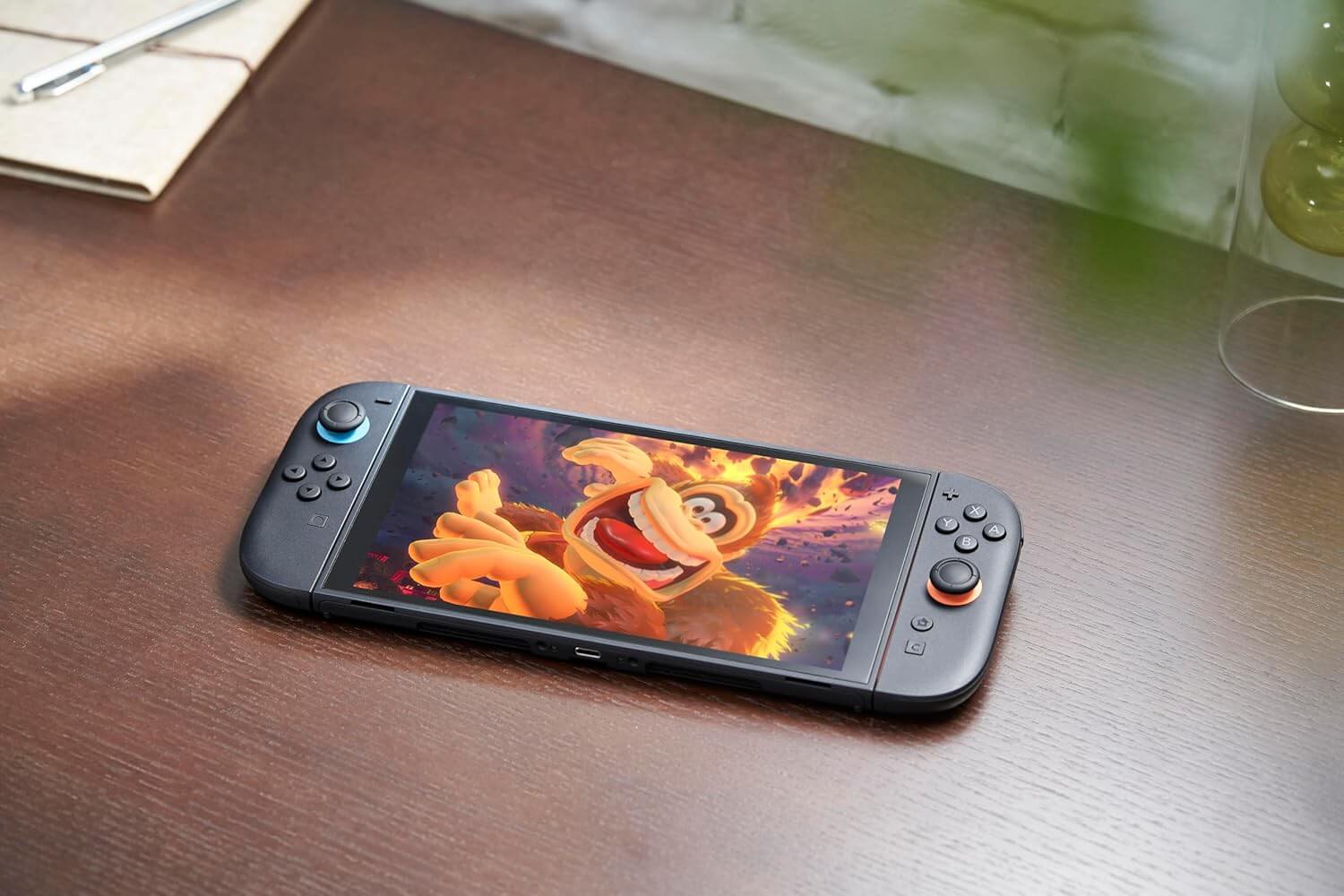 Console Nintendo Switch 2 affichant un personnage de jeu sur l'écran, posé sur une table en bois.