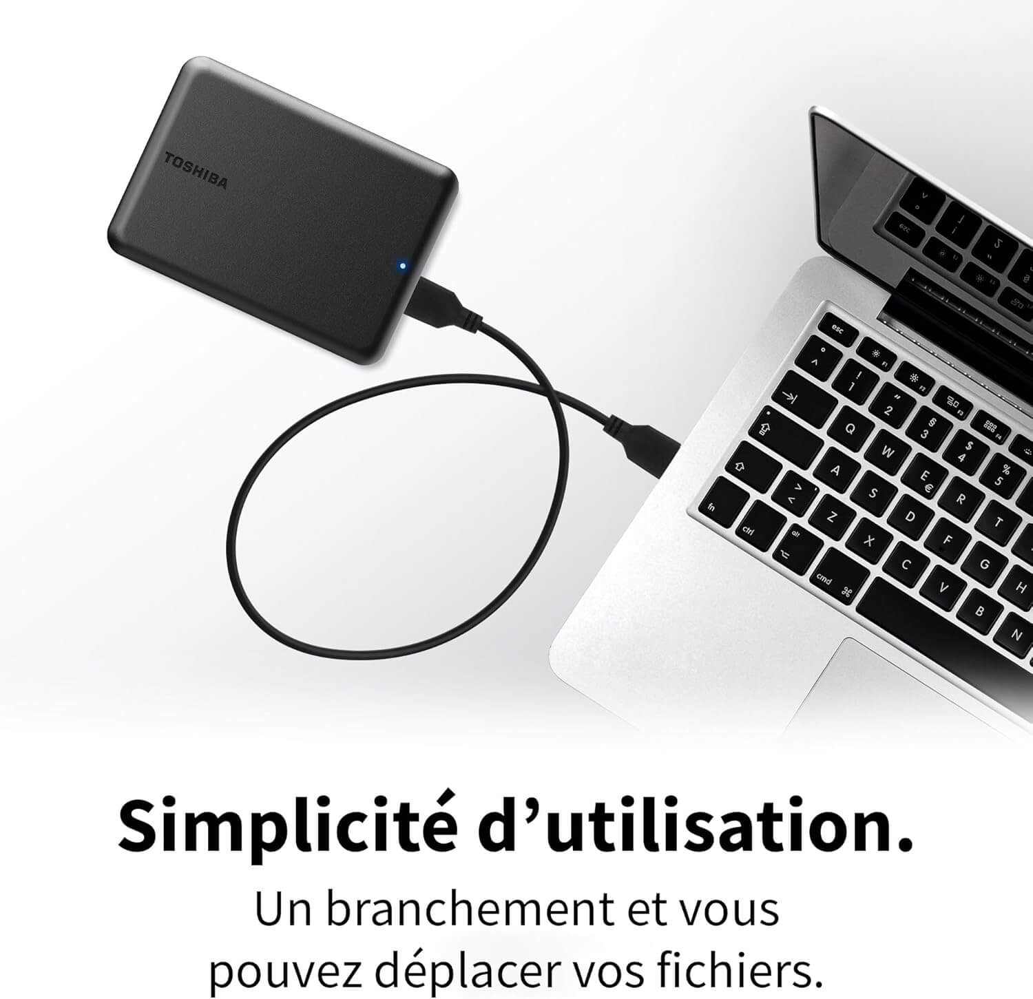 Toshiba Canvio Partner 2TB disque dur externe portable branché à un ordinateur, illustrant la simplicité d'utilisation.