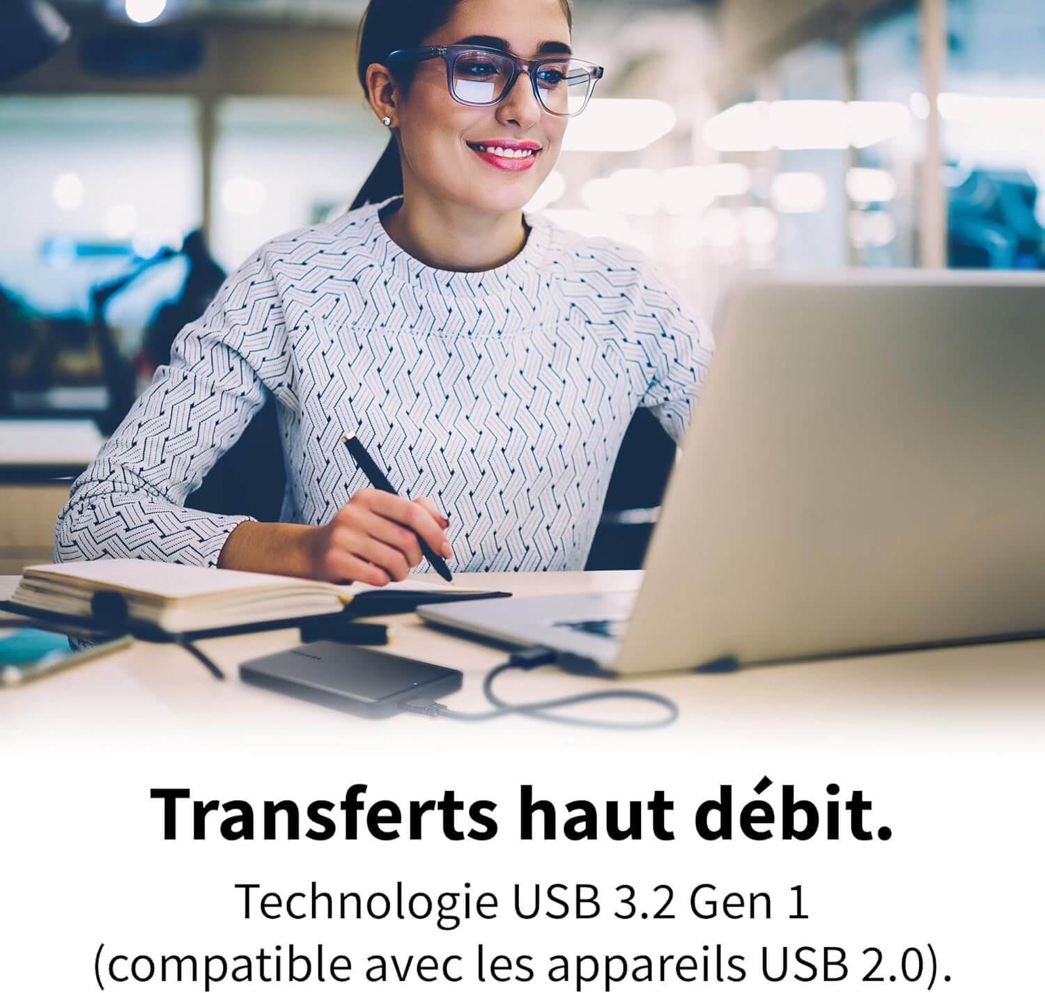 Femme souriante utilisant un disque dur externe Toshiba Canvio Partner 2TB pour des transferts de données rapides.